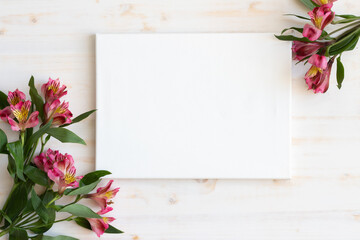 blank canvas with flowers on wooden background