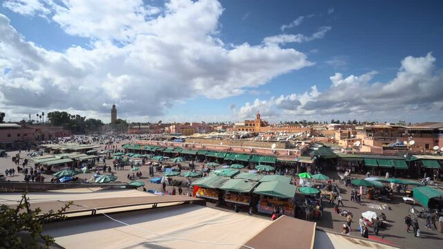 Beautiful sunny day at Jemaa el Fna square in Marrakech, Morocco. Blue sky, summer, crowd, people, market, city scape. 4K Video Footage