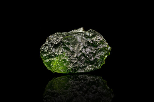 macro stone mineral Moldavite on a black background