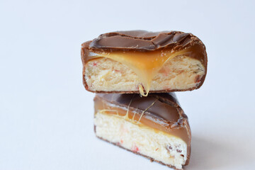 chocolate candy halves. sweets with nougat and caramel are isolated on a white background on top of each other