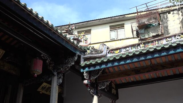 Pagoda roof zoom out in a garden of ancient asian temple, under the blue cloudy sky.