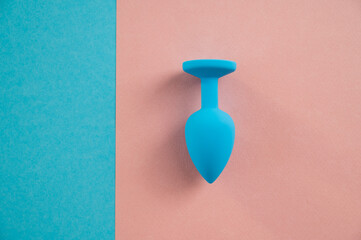 Blue anal plug on a pink background. Plastic sex toy for alternative sex. Copy space.