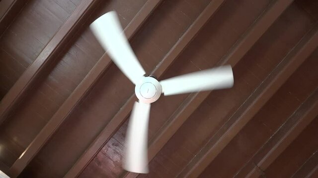 New fan in a ancient asian old house hanging from the ceiling.