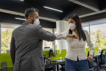 Compañeros de trabajo salundandose con codo distanciamiento social prevencion pandemia