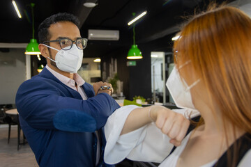 Compa&ntilde;eros de trabajo salundandose con codo distanciamiento social prevencion pandemia