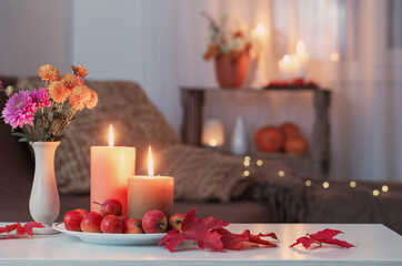 autumn decorations with burning candles at home