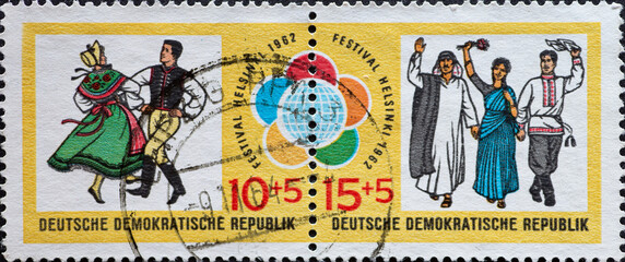 GERMANY, DDR - CIRCA 1962 : a postage stamp from Germany, GDR showing folk dance couple in costume and young people from different nations. World Festival of Youth and Students in Helsinki 1962