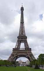 Fototapeta na wymiar View of the Eiffel Tower from the Champ de Mars. Nearby walk tourists