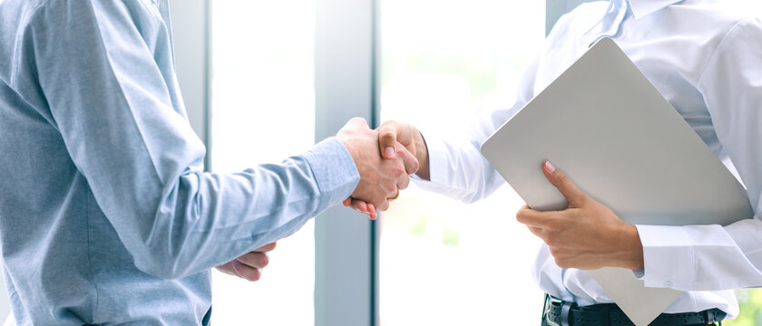 Close up of hand businessman and businesswoman handshake successful business meeting together in the office. Partnership finance teamwork deal business concept, background with panoramic web banner.