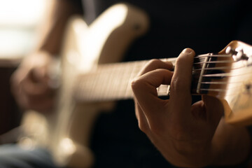 Man playing a white electric guitar. Close-up