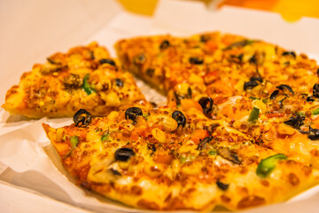 Selective focus close up of fresh cheese pizza with tomatoes, bell pepper, onions and mushrooms.