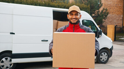 Young indian man delivering parcel. Giving cardboard box. High quality photo