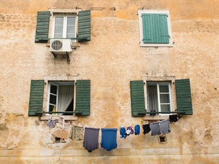 Fototapeta na wymiar The washed clothes are dried on a rope stretched between two windows.
