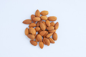 A handful of heap of peeled almonds on white background.