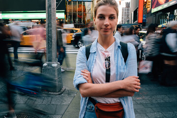 Confident female tourist standing on busy street