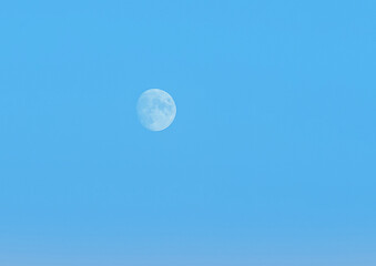 Moon or white planet on blue evening sky at dusk background