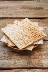 Matza sheets on top of each other lies on a wooden table.