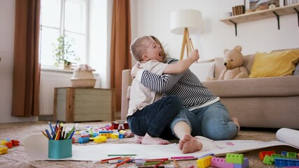 Single mother with down syndrome child at home, drawing pictures. - Powered by Adobe