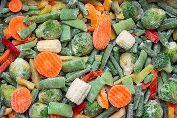Background of a mix of frozen vegetables. Carrots, Brussels sprouts, string beans, peppers, corn....