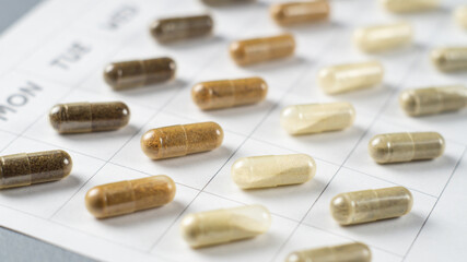 Medicines or dietary supplements on a calendar sheet