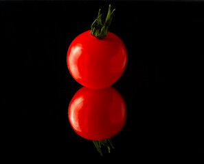 cherry tomato  isolated on black background with reflection