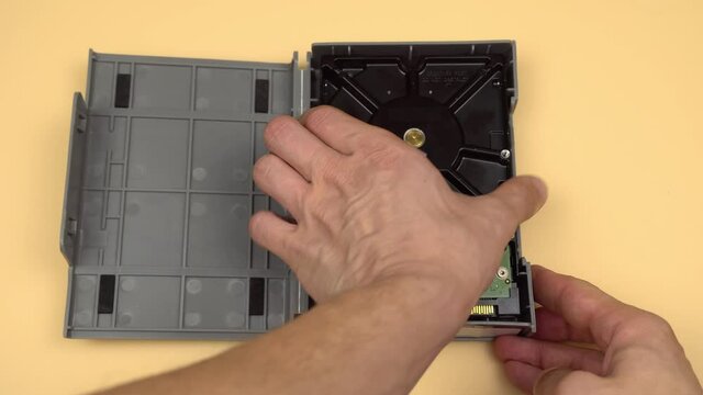 Men's hands open the gray shockproof case and take out the 3.5 HDD, then carefully put it back. The concept of data storage or archive. Important information. Demagnetization.