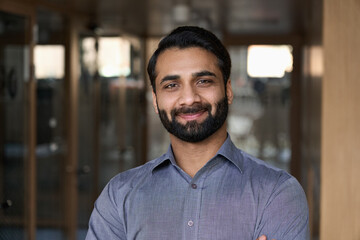 Portrait of young happy indian business man executive looking at camera. Eastern male professional teacher, smiling ethnic bearded entrepreneur or manager posing in office, close up face headshot. - obrazy, fototapety, plakaty