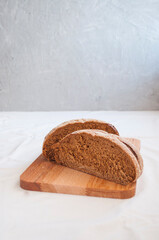 A freshly baked loaf of rye bread on a wooden cutting board. Homemade sourdough rye bread.