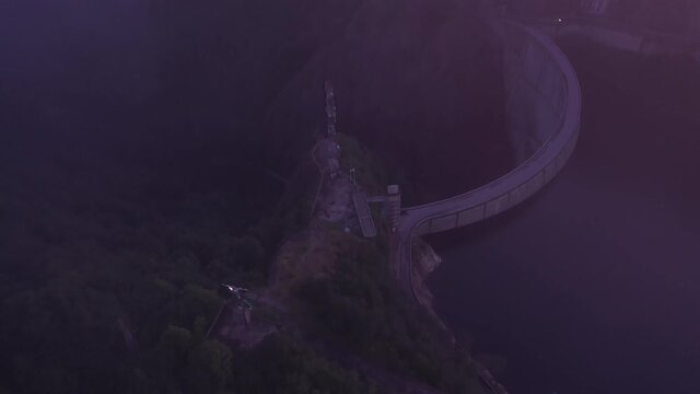Arges River, Romania, 29.07.2019. Aerial shot of Vidraru dam in the evening, zoom out from Prometheus statue in dusk, European sightseeing, tourism landscapes
