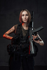 Fototapeta premium Armed with rifle attractive woman in dark background