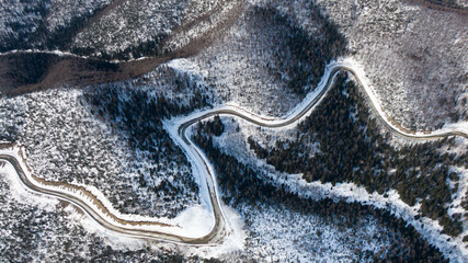 Aerial view of the river and taiga forests and road in the winter - springtime . Abstract landscape of northern nature with drone.
