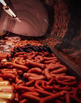 Meat shop's counter with many uncooked fresh meat and sausages