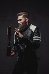Tricky bearded guy posing balancing bottles in studio
