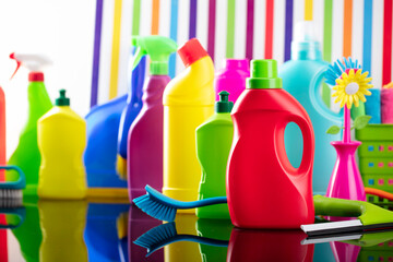 Spring house and office cleaning theme. Colorful set of bottles with clining liquids and colorful cleaning kit on background in the form of colorful stripes.