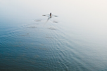 A man is sailing on a boat on the river