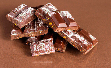 Pieces of chocolate on a brown table.