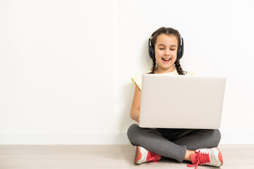 Little funny girl with laptop on white background