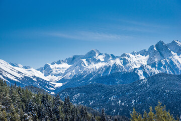 Obraz premium Snow covered Caucasus mountains in winter sunny day. View from ski slope. Arkhyz ski resort, Russia.