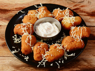 Chicken nuggets served with mayonnaise on wooden background. Dishes and appetizers of indian cuisine, selective focus