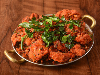 Tasty and Spicy Fried Chicken served on wooden background. Dishes and appetizers of indian cuisine, selective focus
