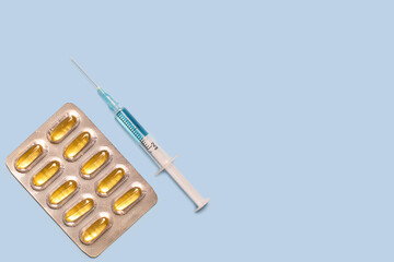 pills syringe with medicine for injection on blue background 