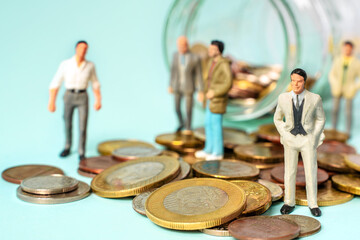 Miniature people stand on coins. Business and Team concept