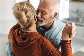 Close up of a happy mature couple having fun while dancing at home
