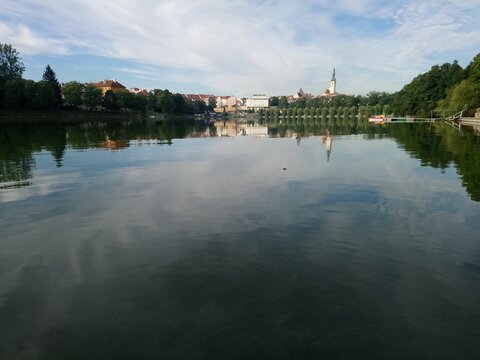 jordan reservoir in T&aacute;bor city czech republic, dam pard in the center with willows ans church behind boat and chill