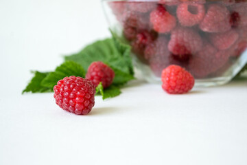 Ripe raspberries with green leaf isolated on white background