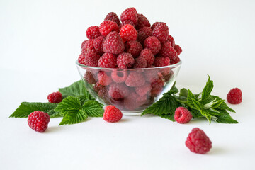 Ripe raspberries with green leaf isolated on white background
