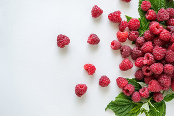 Ripe raspberries with green leaf isolated on white background