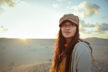 Portrait of a beautiful filipino woman walking alone in the desert - concept of freedom, search, spirituality