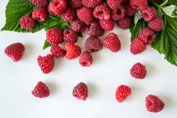 Ripe raspberries with green leaf isolated on white background