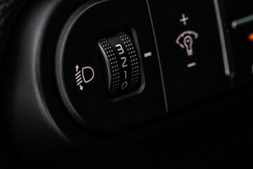 Headlights corrector adjustment buttons. lose up view of the modern car black interior.